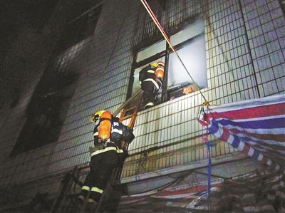 长春一公寓起火 市民合力抬车消防员无氧救人
