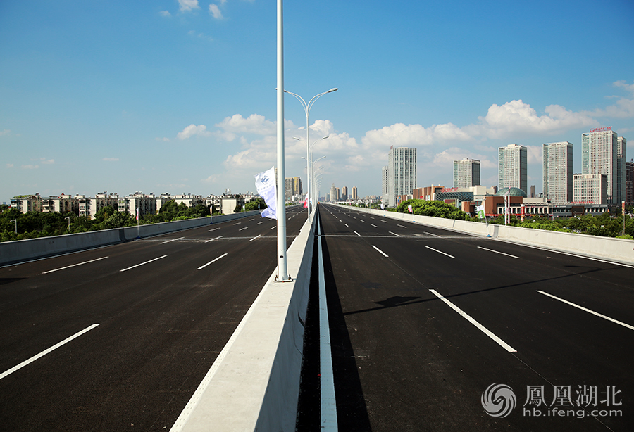 东风大道快速化改造工程一期北起三环线汪家嘴立交，止于莲湖路北侧，全长5.8公里，新建高架桥为双向八车道，地面辅道为双向六车道，高架桥宽度（33米）及车道总数（14条）为武汉已建桥梁道路之最。
    据武汉车都建设投资有限公司负责人介绍，目前，东风大道一期高架桥已完成桥面刷黑、交通标识标线、交通监控、路灯等配设设施建设，高架桥及三角湖路、车城北路、沌阳大道共三对上下桥匝道具备通车条件，计划于后天下午2点通车，设计车速每小时80公里。届时，三镇车辆可经由三环线汪家嘴立交，快捷进入武汉经济技术开发区。图为具备通车条件的东风大道一期高架桥路面情况。 摄影/郑清雄
