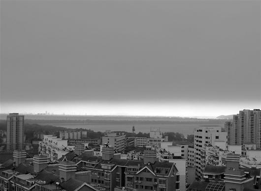 图为：昨日8时许，晴朗的天空突然被大块乌云侵占，江城瞬间“入夜” （记者刘蔚丹摄)