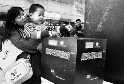 4月22日，一名儿童在家长的带领下为灾区捐款(新华社)