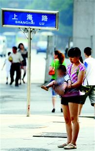 图为：上海路路口，在街头给孩子端尿的家长。
