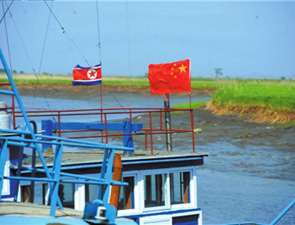 鸭绿江上的渔船悬挂着中朝国旗