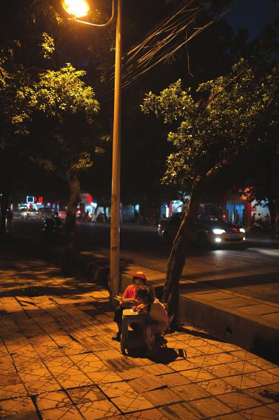 夜晚，路过宜宾火车站到西客站的那段路，很多市民都会看见一位环卫工大姐带着一个小女孩在路灯下读书学习。
这名环卫工大姐名叫吴伟秀，是小女孩的妈妈，因为家里无人辅导女儿的作业，她便将女儿带在身边，一边工作，一边辅导女儿。小女孩说，之所以要跟妈妈来路灯下学习，是因为这里的光线，比家里的亮得多。

