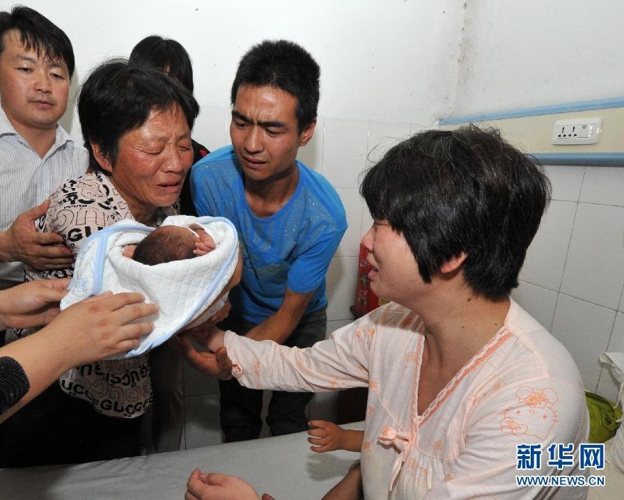 8月5日，陕西省富平县警方将一名被拐婴儿交到其父母手中。富平县刑警大队大队长杨建龙说，相关DNA检测结果显示这名婴儿确定为来国峰夫妇的孩子，DNA检测结果的正式文书将随后送到。 7月16日，富平县薛镇村村民来国峰的妻子董某在富平县妇幼保健院分娩过程中，该院产科副主任张某以“婴儿患有先天性疾病”为由，诱使家属放弃对婴儿治疗并交由自己处理。张某涉嫌于7月17日凌晨以2.16万元将这名男婴卖掉。来国峰夫妇质疑婴儿被拐卖，7月20日报案后，富平县公安局随即全力调查。目前张某等多名犯罪嫌疑人已被依法采取强制措施。图为8月5日，在陕西省富平县妇幼保健院病房内，被拐婴儿的母亲接过失而复得的孩子。