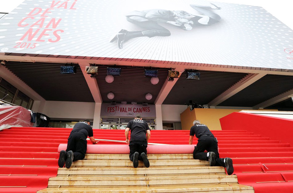 法国当地时间5月14日，戛纳，第66届戛纳电影节即将举行，电影宫进入最后布置阶段，工人们跪地铺设红毯。