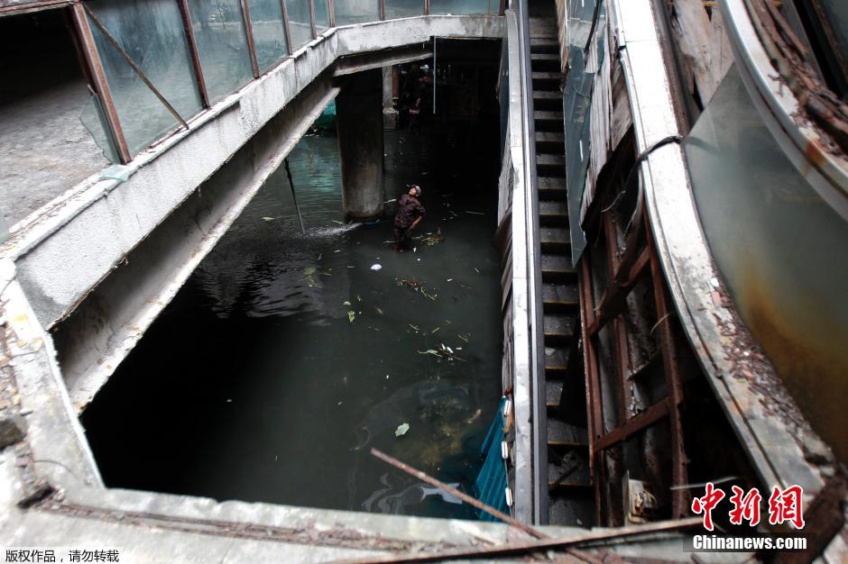 9/9 当地时间2015年1月13日,泰国曼谷,工作人员在一家废弃商场的