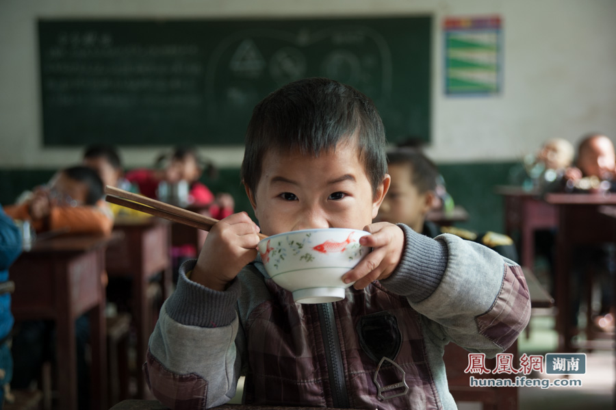 湖南娄底新化县桑梓镇塘冲学校“免费午餐”开餐。正在吃饭的孩子。摄影：童声杨
