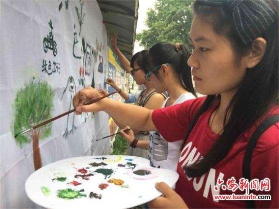 六安大学生墙壁上创意作画 绿色涂鸦宣传世界