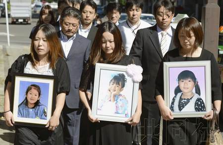 今天上午，仙台地方法院就5名幼儿死于东日本大地震海啸一案宣判。幼儿家属手捧遗照来到法院。（图片来自共同社）