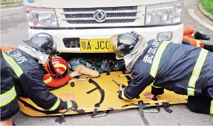 图为消防人员正在全力抢救奶奶李艳芳女士。