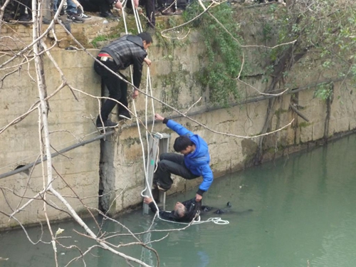 女子失足落水 众市民手拉手搭人梯救人