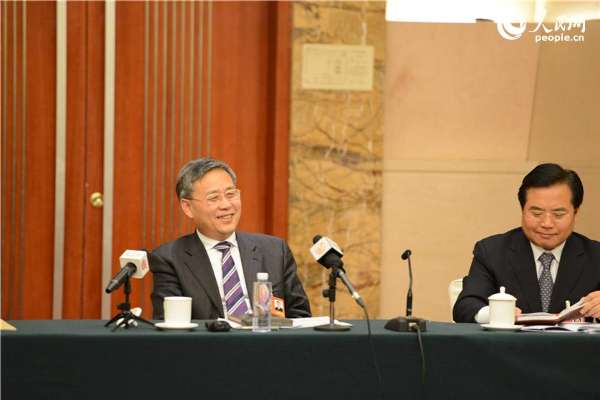 3月6日下午，山东代表团全体会议向中外记者开放，图为山东省省长郭树清（左一）在听到代表发言中的有趣言论面露微笑。（摄影蔡军）