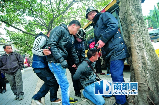 2月16日下午,江会路.警察将嫌疑人的双手反铐.