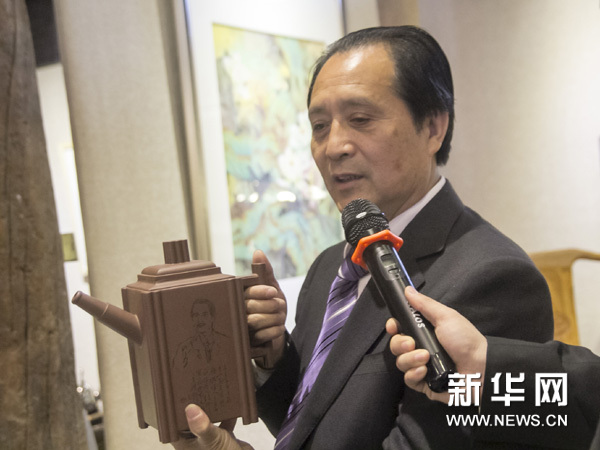 邵顺生先生展示其亲手制作的‘顶天立地”紫砂壶，并阐述了其中蕴含的历史文化背景。新华网图片 何从 摄