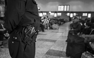 (▲5月4日下午，长沙火车站候车室，铁路公安民警带枪巡逻。记者 唐俊 摄)