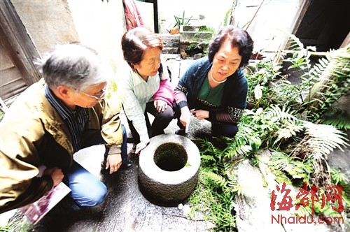 黄聚华的后人（右一）和工作人员来到古井前，讲述当年的故事