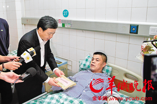 中山市副市长、公安局局长谭培安将见义勇为奖励金递给躺在病床上的覃钊茂