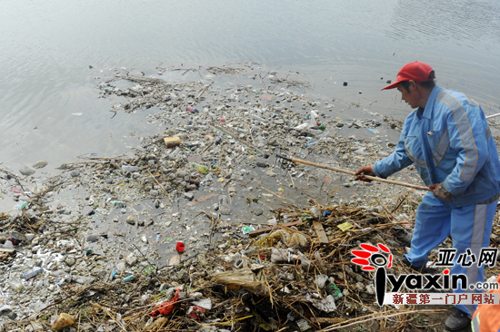 环卫工在清理水库中的垃圾。亚心网记者 张已 摄