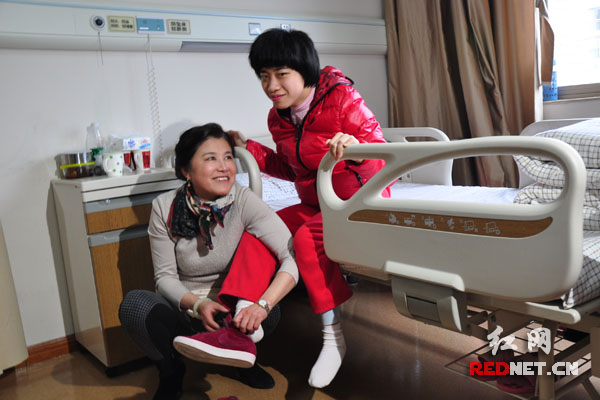 (任菲莉每天要抱着两个女儿上下床，搀扶她们做康复训练。)