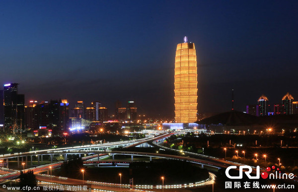 　　5月28日晚，河南省郑州市，站在金水路与通泰路交叉口的高楼顶端向前望去，郑州会展宾馆如同一个巨大的金黄色“玉米棒”矗立在郑东新区CBD中央，成为一道靓丽风景。　图片来源：卢键/CFP