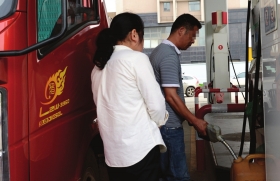 5月29日,长沙香樟东路与体院路交会处,货车司机在附近一家加油站用散装塑料桶加油。图/记者陈勇