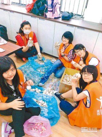 蒜价格直直落，台中科技大学学生协助蒜农剥蒜。  台湾《中国时报》图