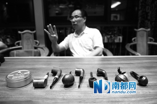 斗友彪哥向记者介绍其收藏的八个烟斗。