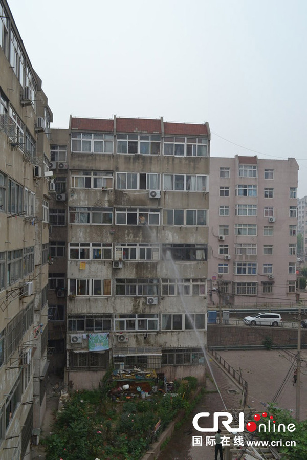 青岛<em>男子</em>欲跳楼轻生 被高压水枪喷回<em>屋</em>内(高清