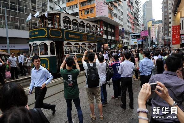 6月20日，市民在香港湾仔拍摄乘坐电车的纸糊大熊猫。