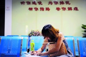 阿玲(化名)在妇联填写求助信息,她自称左臂被家人打伤,留下三道伤痕。信息时报见习记者 陈引 记者 朱元斌 摄