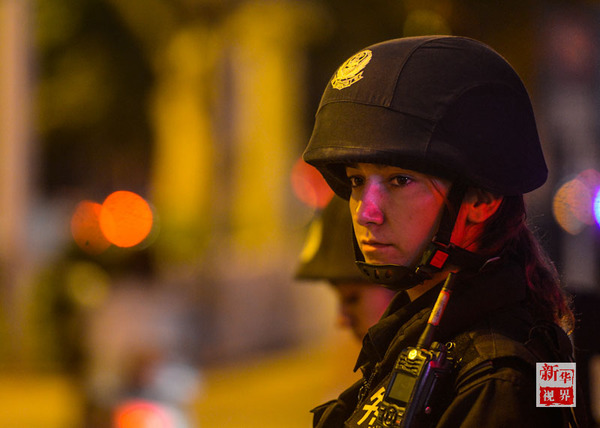 ↑迪丽热巴在一处闹市区进行定点武装震慑,此时的她正机警地注视前方(2014年7月15日摄)。