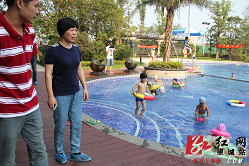 副区长苏敏芳（前排左二）在区时代倾城游泳池了解免费游泳情况。解巾英 摄