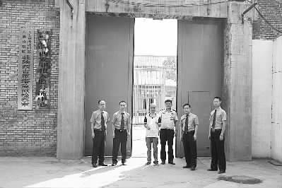 王江峰在检察官和狱警陪同下走出大墙