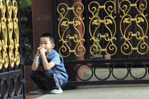 武成小学，家长在排队报名，孩子蹲在校门口 ■ 都市时报记者 张玉杰