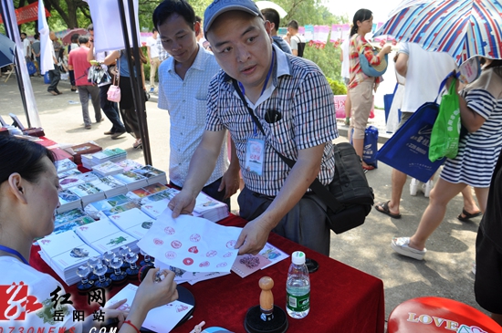 一集邮者在爱情邮局服务点，购买爱情邮资信封，加盖爱情纪念邮戳。