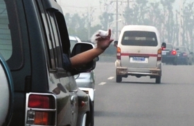 长沙市西二环，越野车上的乘客随手将纸巾扔出窗外。资料图片