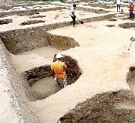 考古工作人员在发掘工地清理灰坑。 中新社发 杨正华 摄-图片版权归原作者所有