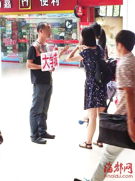 男子举着﹃大学城﹄牌子，不断有女大学生上前询价