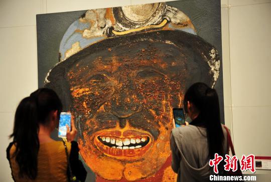 观众正在用手机拍摄画展上的作品。 翟羽佳 摄