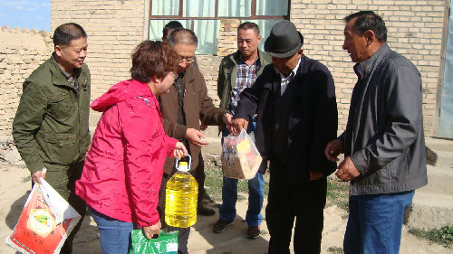 图片为农行伊犁兵团支行行长袁媛给四连贫困职工木合它尔&middot;加合白送上慰问品。