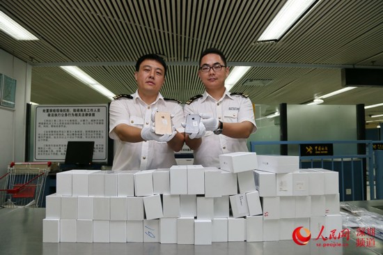 深圳罗湖海关关员展示被查获iPhone 6（深圳罗湖海关供图）