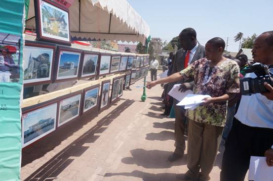 9月27日,坦桑尼亚多多马大学孔子学院在坦桑尼亚首都多多马中心广场举办“孔子学院日”系列活动。图为评委观摩图片作品。多多马大学孔子学院供稿。
