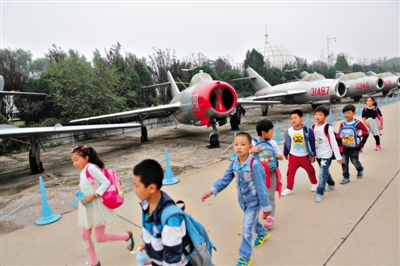小学生在中国航空博物馆参观“少年先锋号”米格-15飞机。近日，该馆106架飞机被评为一级文物。本版图片/新京报记者秦斌