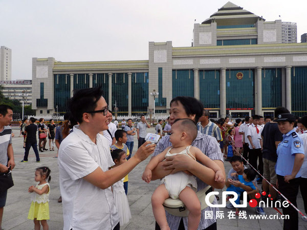 北部湾之声记者许星采访早早到民族广场参加升旗仪式的祖孙两