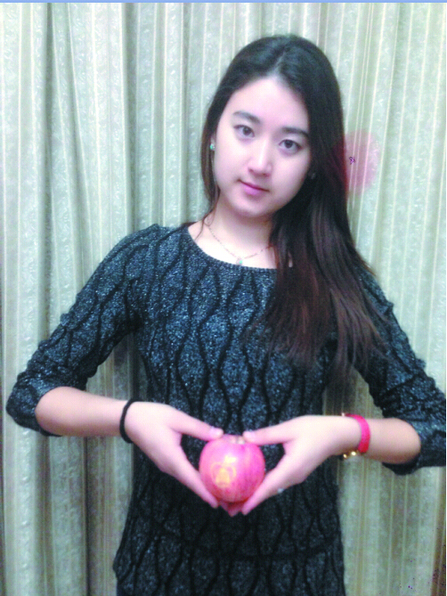 ▲阿依苏丽坦·艾依克热木展示收到的阿克苏苹果。