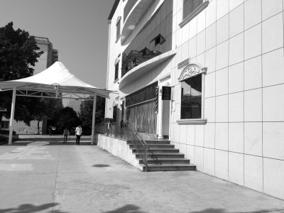 酒店一侧的墙上，装有“足疗棋牌”的指示灯箱。