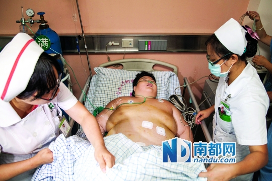 8月23日,小周磊的胃旁路手术顺利结束后回到病房,医护人员正在照料他。