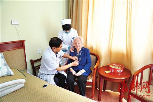 附一护养中心的健康咨询师在为老人检查身体