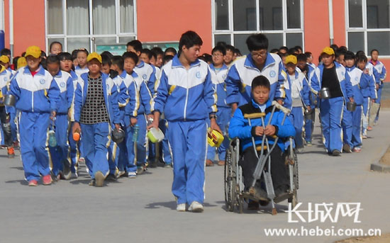 武强县第二实验中学学生帮助残疾同学.刘金英 提供