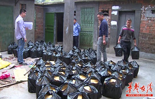 　　警方从李小凤家的杂物间查获的白酒。警方视频截图。